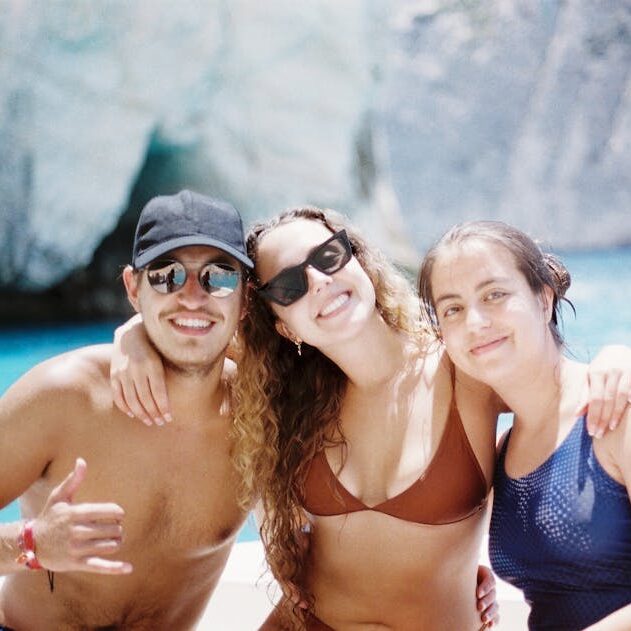 Three friends on a boat having fun in sun. Perfect for vacation memories.
