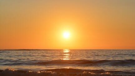 Breathtaking view of a vibrant sunset over the ocean waves, perfect for tranquil seascape imagery.